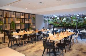シドニーにあるメトロ アスパイア ホテル シドニーのテーブルと椅子、植物のあるレストラン