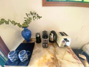 a table with cups and a toaster and a vase at Evermoore Homestead in Gleniffer