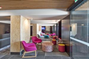 - un hall avec des chaises colorées et une table dans l'établissement Metro Hotel Perth, à Perth