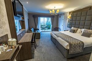 a hotel room with a large bed and a desk at Dryfesdale Hotel - BW Signature Collection in Lockerbie