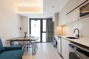 cocina y sala de estar con mesa y sillas en FLORIT FLATS - The Green Apartments en Valencia