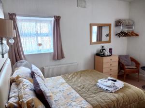 - une chambre avec un lit, un miroir et une fenêtre dans l'établissement Stafford House, à Blackpool
