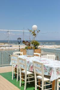 un tavolo e sedie su un balcone con vista sull'oceano di Hotel Villa Maris a Rimini