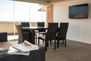 a dining room with chairs and a table with a television at Samaya Sea view in Civitavecchia