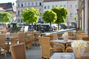 uma fila de mesas e cadeiras numa rua da cidade em City Hotel Morris em Ceská Lípa