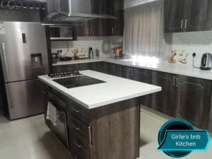 uma cozinha com uma placa de fogão e um frigorífico em Girlie's bed and breakfast em Kopong