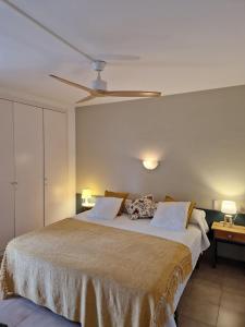 um quarto com uma cama grande e uma ventoinha de tecto em Acogedor apartamento en l'Estartit con piscina y Parking em L'Estartit