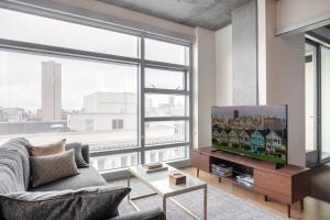 uma sala de estar com televisão e uma grande janela em Lower Nob Hill 2BR w Roofdeck BBQ nr Shops SFO-183 em São Francisco