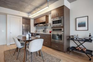 a kitchen with a table and chairs and a microwave at Lower Nob Hill 2BR w Roofdeck BBQ nr Shops SFO-183 in San Francisco