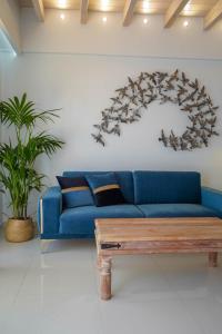 a living room with a blue couch and a wooden coffee table at Liberte Maisonettes in Parga
