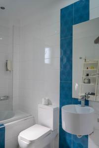 a white bathroom with a toilet and a sink at Liberte Maisonettes in Parga