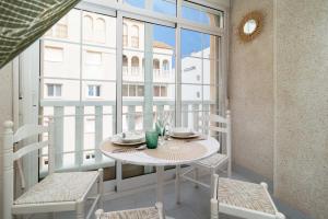 トレビエハにあるEspanatour BENIAJANの大きな窓のある客室で、テーブルと椅子が備わります。