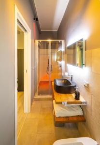 ein Bad mit einem schwarzen Waschbecken und einer Dusche in der Unterkunft LOFT85 - Self check-in centro! in Messina