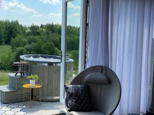 Kowale OleckieGLAMP GLAMOUR*****的窗户客房内的椅子和浴缸