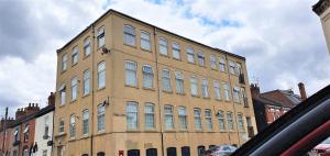 a large brick building with many windows on a street at Shakespeare Views - Modern Northampton Apartment in Northampton