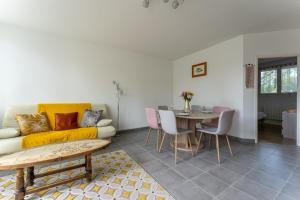 a living room with a couch and a table at Le Chemin du bois - Proche station de ski in Saint-Laurent-en-Grandvaux