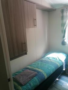 a small bedroom with a bed and a cabinet at Nordik in Alheim