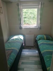 two beds in a small room with a window at Nordik in Alheim