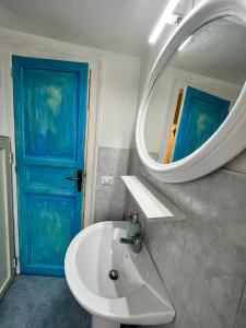 a bathroom with a white sink and a blue door at Mille Lire in Palermo