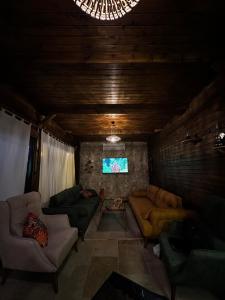 a living room with couches and a flat screen tv at Villa Vazgeçilmezim Deniz Manzaralı ,Sessiz,Sakin in Fethiye