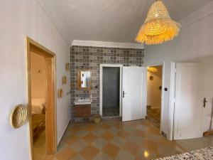 a living room with a chandelier and a bathroom at West coast surf house in Imsouane +118 photos