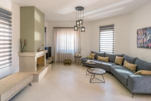 a living room with a couch and a fireplace at Villa Dianna Gouves in Gournes