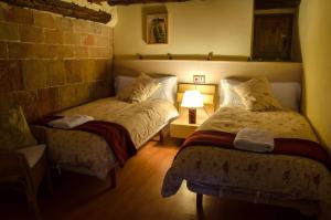 a bedroom with two beds and a lamp in it at CAL ESCALER in Caserras