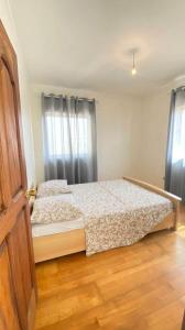 um quarto com uma cama e piso em madeira em Perfect Place em Tarrafal