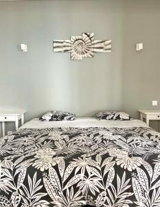 una camera con un letto con una coperta bianca e nera di Pirata hostel Milfontes a Vila Nova de Milfontes