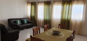 uma sala de estar com uma mesa e um sofá em Perfect Place em Tarrafal