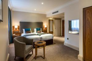 Pokój hotelowy z łóżkiem i krzesłem w obiekcie Thistle London Marble Arch w Londynie