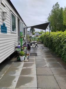 a patio with a tent and plants next to a house at "Dew Drop Inn" in Port Seton