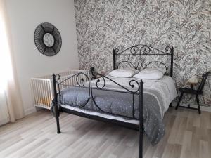 a bedroom with a black bed with a wallpaper at Mon petit paradis in Longeville-sur-Mer