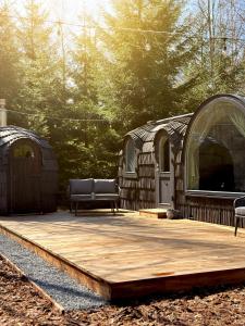 a wooden deck with a couch and two domes at Pedaspä Igloo House and Sauna in Pedaspea