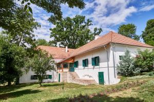a white house with a red roof at VILLABOGArT Esküvő-és Rendezvényhelyszín in Alsobogát