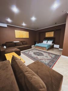 a living room with a bed and a couch at TURAN SEMEY GRAND HOTEL in Semey
