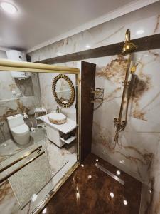 a bathroom with a shower and a toilet and a sink at TURAN SEMEY GRAND HOTEL in Semey