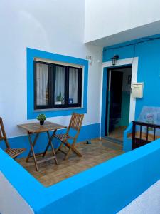 ヴィラ・ノヴァ・デ・ミルフォンテスにあるPirata hostel Milfontesのテーブルと椅子、窓が備わる客室です。