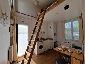 a small kitchen with a ladder in a tiny house at Tiny house avec jardin spacieux in Saint-Nazaire