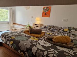Schlafzimmer mit einem Bett mit einer blumengeschmückten Bettdecke in der Unterkunft Tiny house avec jardin spacieux in Saint-Nazaire
