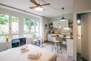 una cocina con armarios blancos y una mesa en una habitación en Cardabelle - Joli appt pour 2 avec parking privé, en Millau