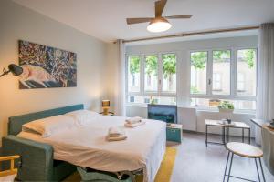 een slaapkamer met een bed en een groot raam bij Cardabelle - Joli appt pour 2 avec parking privé in Millau