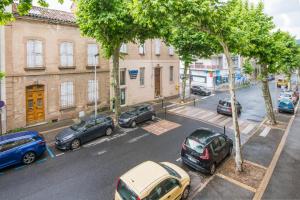 een groep auto's geparkeerd in een stadsstraat bij Cardabelle - Joli appt pour 2 avec parking privé in Millau