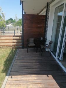 a deck with a table and chairs on a house at Do Morza 1 in Mechelinki