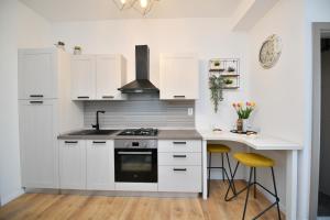 a kitchen with white cabinets and a counter with a desk at Palomino apartment in Sinj