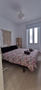 1 dormitorio con 1 cama grande con una manta colorida en Casa Eguino- Pet Friendly, en San Sebastián