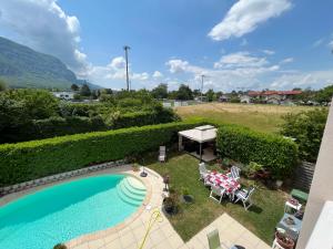 a backyard with a pool and a table and chairs at Chambres dans villa avec piscine in Veyrier