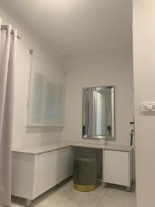 bagno bianco con lavandino e specchio di The Nest Apartment a Città di Zante