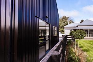a black house with a large window on the side of it at Matamata Country Retreat in Matamata