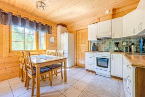 a kitchen with white cabinets and a table and chairs at Himos Huili 1 in Jämsä